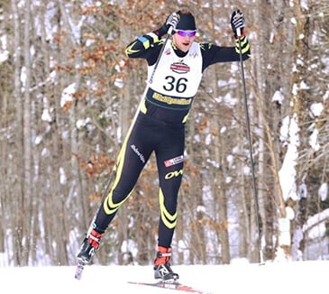 Action shot of Tom outside cross-country skiing in a black outfit
